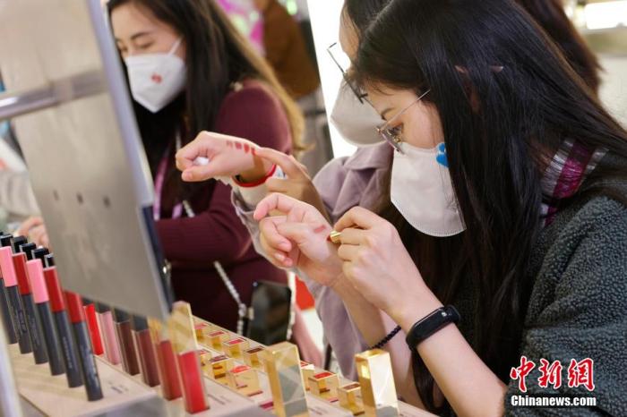 圖為女生正在體驗(yàn)口紅產(chǎn)品。 殷立勤 攝