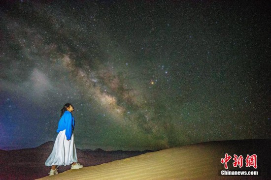 圖為6月20日晚,游客在西藏阿里暗夜公園與銀河“合影”。曹枝清 攝