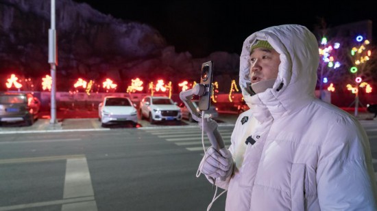 在吉林市阿什哈達(dá)霧凇觀景帶，霧凇播報(bào)員正在直播。新華社記者 李典 攝