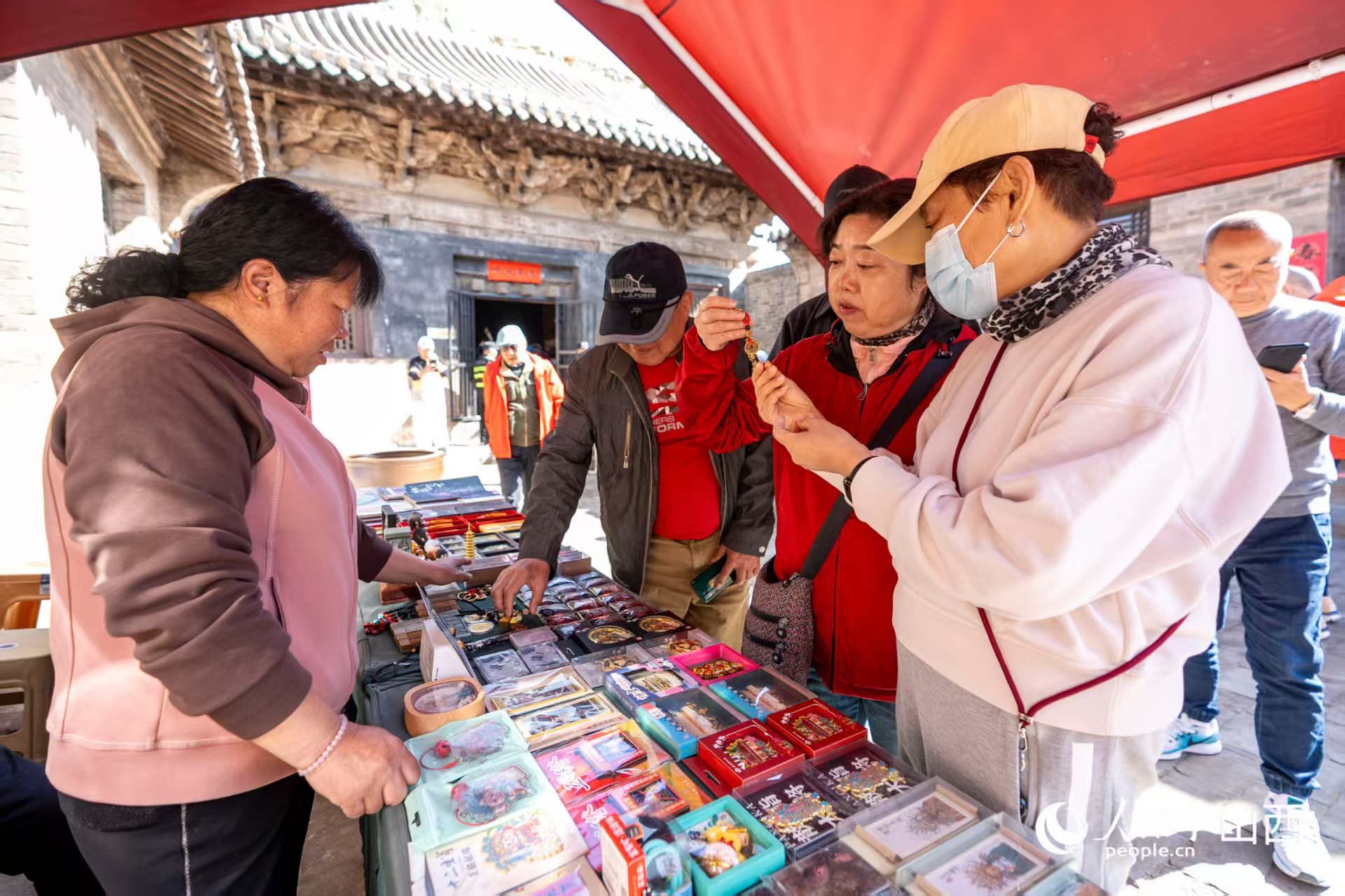 游客在山西省高平市鐵佛寺選購(gòu)文創(chuàng)產(chǎn)品。人民網(wǎng)記者 盧鵬宇攝