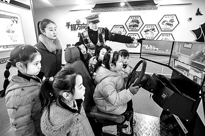 山東省榮成市公安局道路交通安全宣傳教育基地，交警帶領(lǐng)小學(xué)生現(xiàn)場體驗(yàn)?zāi)M駕駛。新華社發(fā)