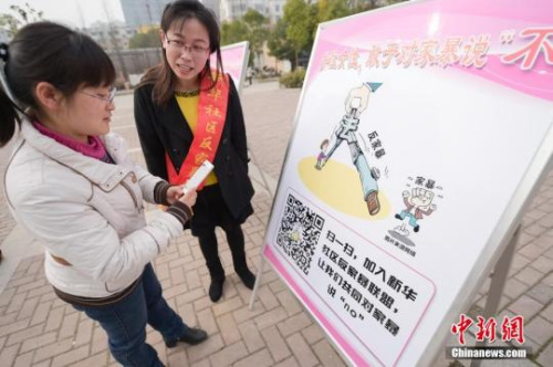 資料圖：今年3月8日，安徽合肥新華社區(qū)志愿者夏一瓊(右)向市民普及反家暴相關(guān)法律知識。鐘欣 攝