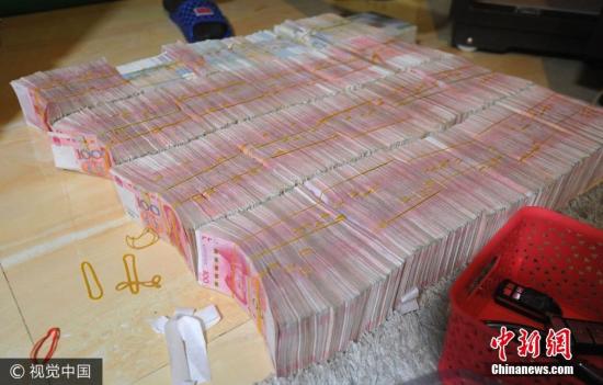 廣西南寧警方8月21日通報，當(dāng)?shù)亟粘晒善粕姘附痤~15.19億元人民幣的特大傳銷案件。圖為當(dāng)場繳獲的成捆現(xiàn)金。圖片來源：視覺中國