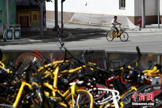 上?，F(xiàn)共享單車“墳?zāi)埂?堆積如山場面壯觀。 張亨偉 攝